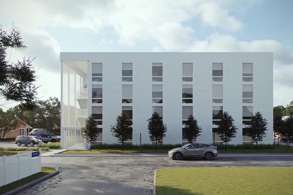 A four-story Vessel building on a residential street, as rendered in the company's flyby: white modular facade with rows of large windows