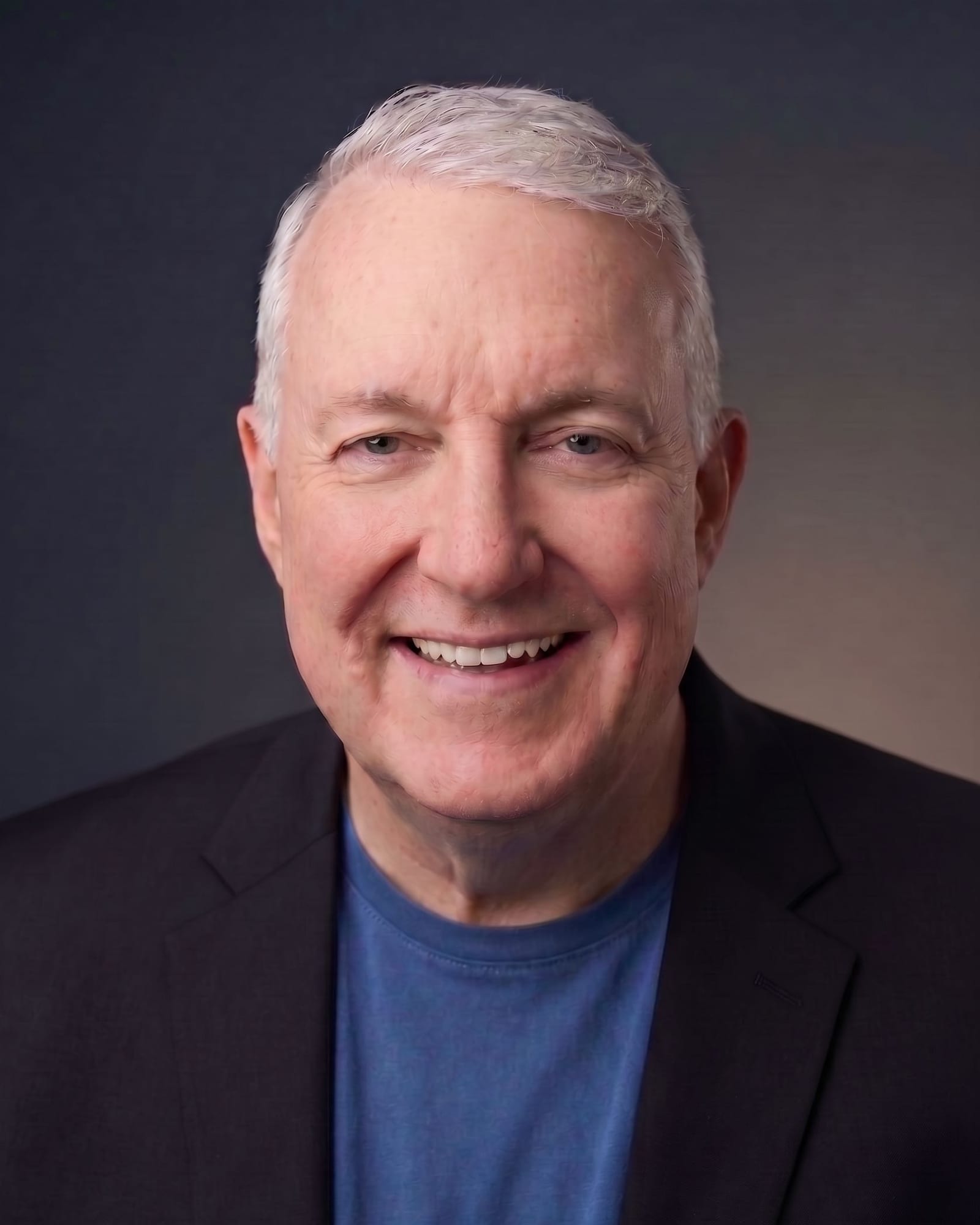 Jim Kitchen, head-and-shoulders portrait against a dark neutral ground.
